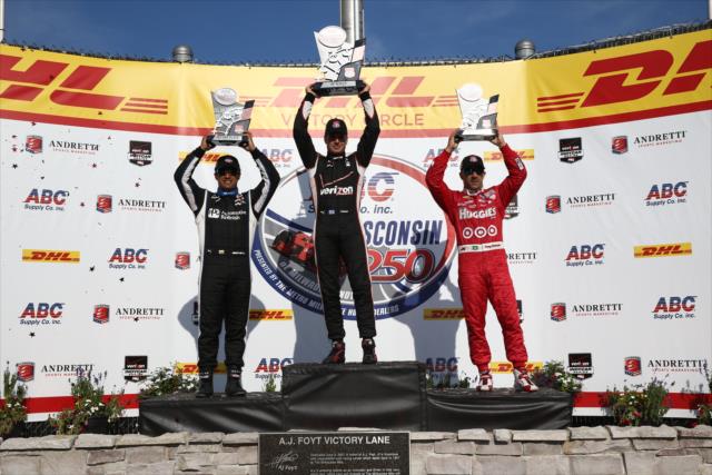Will Power, Juan Pablo Montoya, and Tony Kanaan hoist their trophies on the podium following the ABC Supply Wisconsin 250 at the Milwaukee Mile -- Photo by: Chris Jones