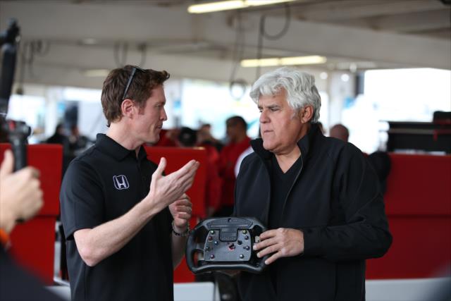 Scott Dixon describes the nuanaces of his steering wheel to Jay Leno back in the Phoenix International Raceway paddock -- Photo by: Chris Jones