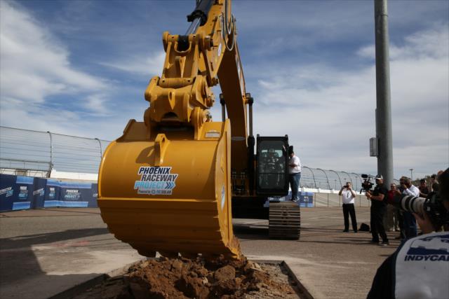 Helio Castroneves mans the excavator to break ground for the Phoenix International Raceway modernization project -- Photo by: Chris Jones