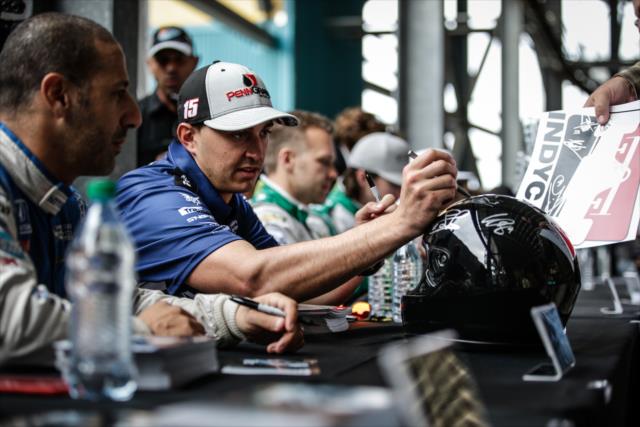 Graham Rahal signs a helmet during the autograph session in between test sessions at Phoenix International Raceway -- Photo by: Shawn Gritzmacher