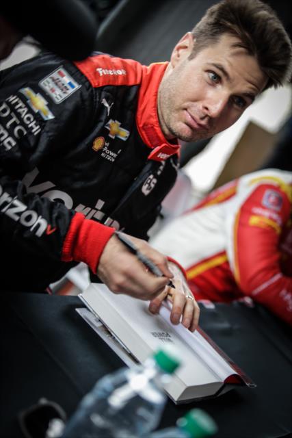 Will Power signs his book during the autograph session in between test sessions at Phoenix International Raceway -- Photo by: Shawn Gritzmacher