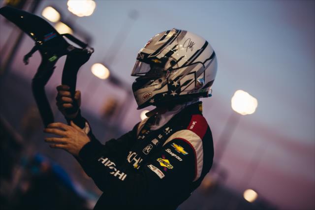 Josef Newgarden puts on his HANS Device on pit lane during the evening test session at ISM Raceway -- Photo by: Stephen King