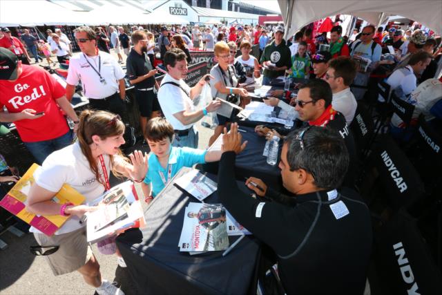 Juan Pablo Montoya gives a high-five during the autograph session in the INDYCAR Fan Village at Pocono Raceway -- Photo by: Bret Kelley