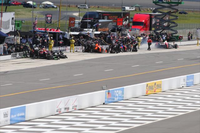 Pit lane gets active during the first round of pit stops for the Pocono INDYCAR 500 -- Photo by: Bret Kelley