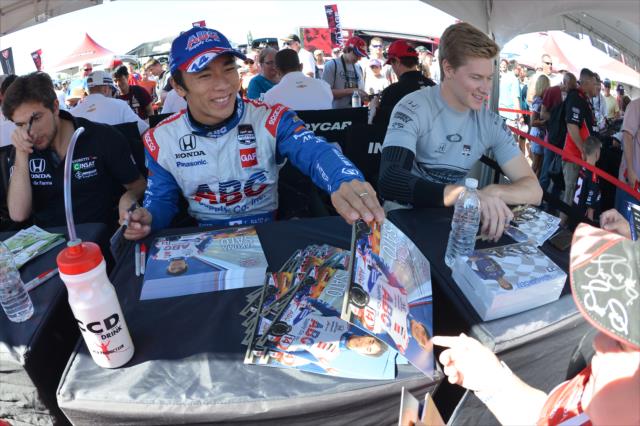 Takuma Sato and Josef Newgarden sign some autographs in the INDYCAR Fan Village -- Photo by: Chris Owens