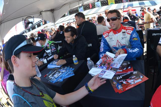 Teammates Carlos Huertas and Justin Wilson sign autographs in the INDYCAR Fan Village -- Photo by: Chris Owens