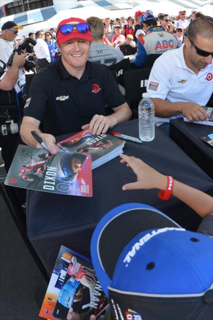 Scott Dixon signs an autograph for a young fan in the INDYCAR Fan Village -- Photo by: Chris Owens