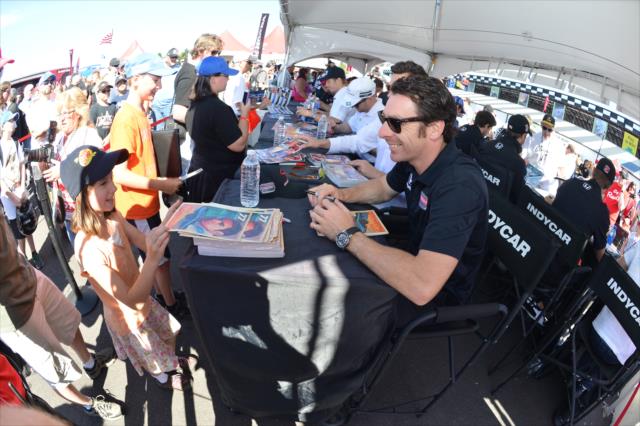 Simon Pagenaud signs an autograph for a young fan in the INDYCAR Fan Village at Pocono Raceway -- Photo by: Chris Owens