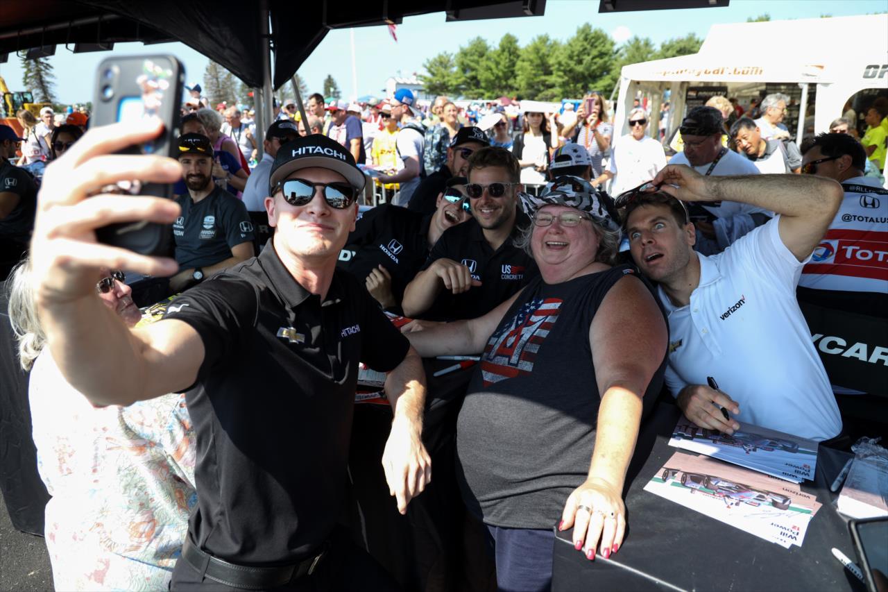 Josef Newgarden, Zach Veach, Marco Andretti and Will Power take a photo with a fan -- Photo by: Joe Skibinski