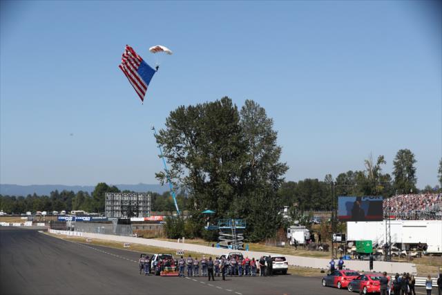 Team FasTrax brings in the American flag during pre-race festivities for the Grand Prix of Portland at Portland International Raceway -- Photo by: Chris Jones