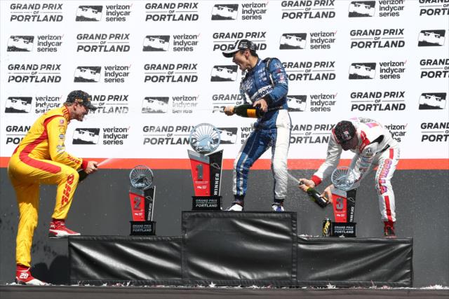 The champagne sprays in Victory Circle for Takuma Sato, Ryan Hunter-Reay, and Sebastien Bourdais following the Grand Prix of Portland at Portland International Raceway -- Photo by: Chris Jones