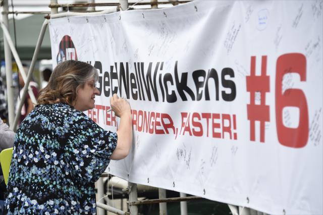 A fan signs a #GetWellWickens banner in the stands at Portland International Raceway -- Photo by: Chris Owens