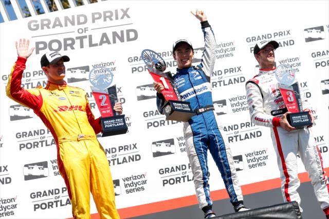 The podium of Takuma Sato, Ryan Hunter-Reay, and Sebastien Bourdais waive to the crowd in Victory Circle after the Grand Prix of Portland at Portland International Raceway -- Photo by: Joe Skibinski