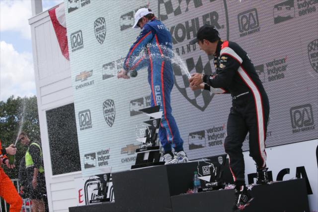 Scott Dixon and Helio Castroneves spray the champagne in Victory Circle following the KOHLER Grand Prix -- Photo by: Joe Skibinski