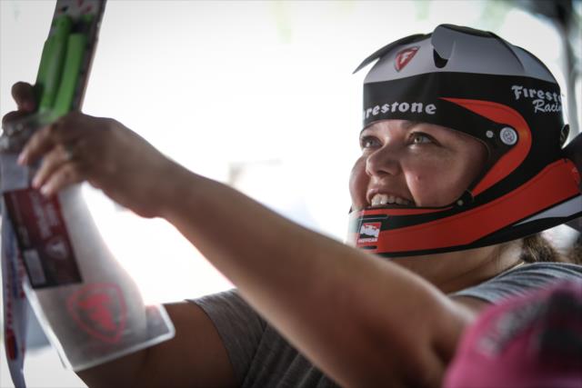 A fan takes a selfie with a Firestone helmet in the Firestone Fan Village at Road America -- Photo by: Shawn Gritzmacher