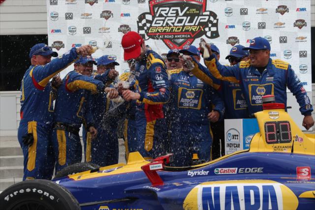 Alexander Rossi celebrates with his team in victory circle after winning the REV Group Grand Prix at Road America. -- Photo by: Chris Jones