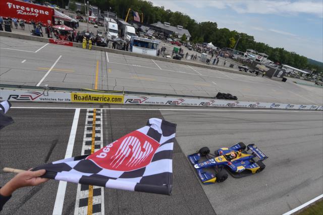 Alexander Rossi takes the checkered flag to win the REV Group Grand Prix at Road America -- Photo by: John Cote