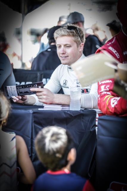 Spencer Pigot signs an autograph during the Fan Village autograph session in St. Petersburg -- Photo by: Shawn Gritzmacher