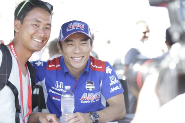 Takuma Sato poses for a photograph during the autograph session in the St. Petersburg Fan Village -- Photo by: Shawn Gritzmacher