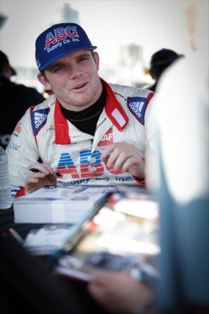 Conor Daly signs an autograph during the autograph session in the St. Petersburg Fan Village -- Photo by: Shawn Gritzmacher