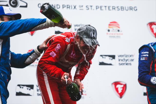 Sebastien Bourdais receives a champagne shower from Simon Pagenaud in Victory Circle following the Firestone Grand Prix of St. Petersburg -- Photo by: Joe Skibinski