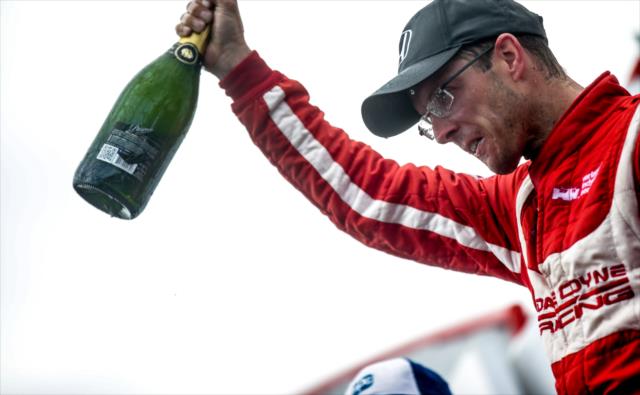 Sebastien Bourdais holds his champagne bottle high in Victory Circle following his win in the Firestone Grand Prix of St. Petersburg -- Photo by: Shawn Gritzmacher