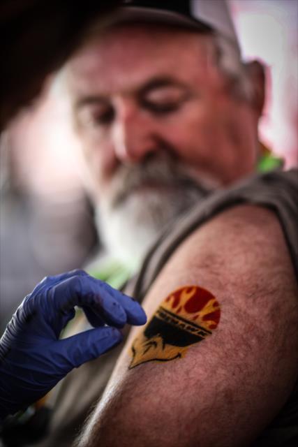 A fan gets a temporary Firestone Firehawk tattoo in the INDYCAR Fan Village at St. Petersburg -- Photo by: Shawn Gritzmacher