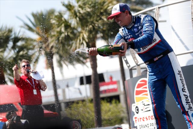 Graham Rahal sprays champagne toward his team in Victory Circle after his 2nd Place finish in the Firestone Grand Prix of St. Petersburg -- Photo by: Joe Skibinski