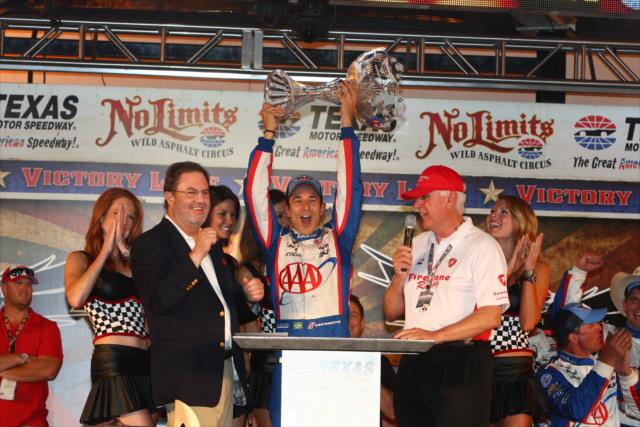 Helio Castroneves hoists his 1st place trophy for the Firestone 550 -- Photo by: Chris Jones