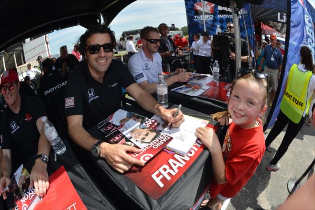 Dario Franchitti signs an autograph for a young fan -- Photo by: John Cote