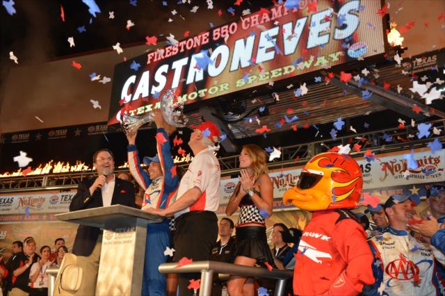 Confetti flies as Helio Castroneves hoists the winner's trophy at Texas Motor Speedway -- Photo by: John Cote