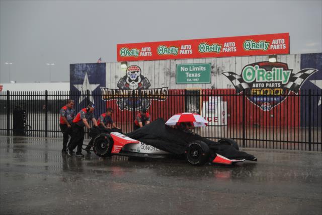 The covered car of Marco Andretti being pushed back to the garages through the rain -- Photo by: Chris Jones