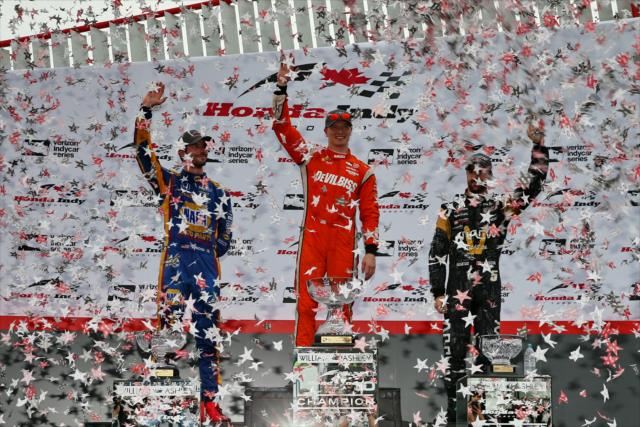 The confetti flies as Josef Newgarden, Alexander Rossi, and James Hinchcliffe hoist their trophies in Victory Circle following the Honda Indy Toronto -- Photo by: Chris Jones