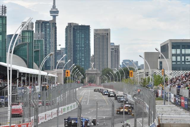 The field streams down the frontstretch during the Honda Indy Toronto -- Photo by: Chris Owens