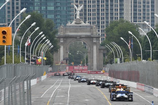 The field streams down the frontstretch into Turn 1 during the Honda Indy Toronto -- Photo by: Chris Owens