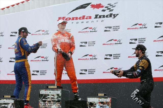 Josef Newgarden, Alexander Rossi, and James Hinchcliffe spray the champagne in Victory Circle after the Honda Indy Toronto -- Photo by: Joe Skibinski