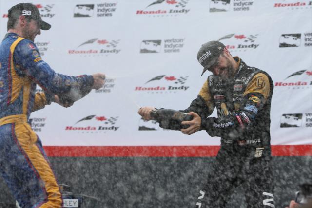 James Hinchcliffe and Alexander Rossi spray the champagne in Victory Circle following their podium finishes in the Honda Indy Toronto -- Photo by: Joe Skibinski