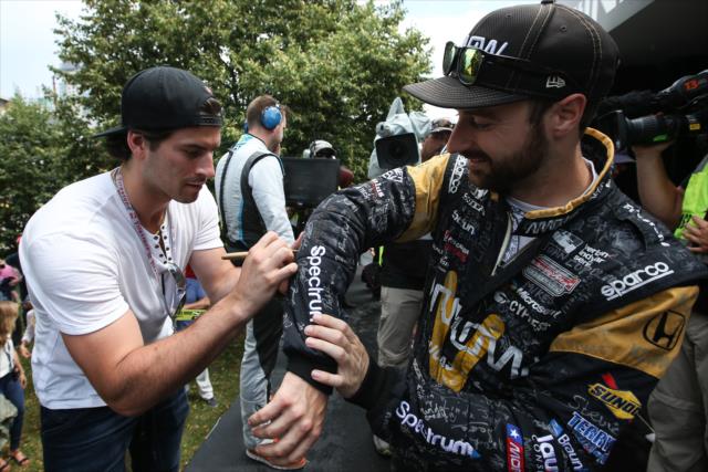 James Hinchcliffe gets his firesuit signed by Adam Henrique of the New Jersey Devils backstage during pre-race festivities for the Honda Indy Toronto -- Photo by: Joe Skibinski