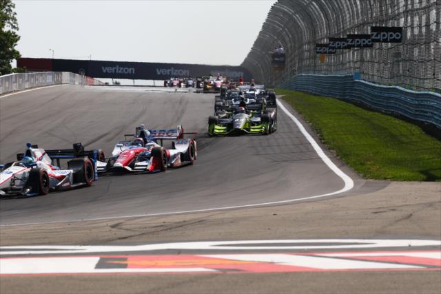 The field streams into Turn 1 during the INDYCAR Grand Prix at The Glen from Watkins Glen International -- Photo by: Bret Kelley