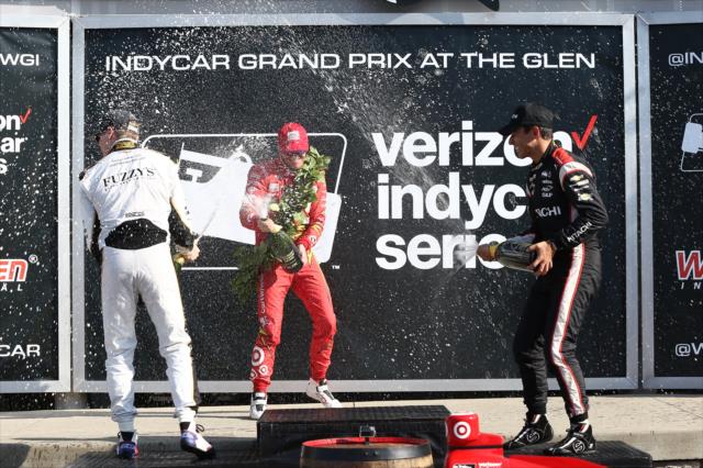 The podium of Scott Dixon, Helio Castroneves, and Josef Newgarden spray the champagne in Victory Lane following the INDYCAR Grand Prix at The Glen from Watkins Glen International -- Photo by: Chris Jones