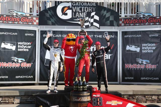 The podium of Scott Dixon, Helio Castroneves, and Josef Newgarden pose with the Firestone Firehawk in Victory lane following the INDYCAR Grand Prix at The Glen from Watkins Glen International -- Photo by: Chris Jones