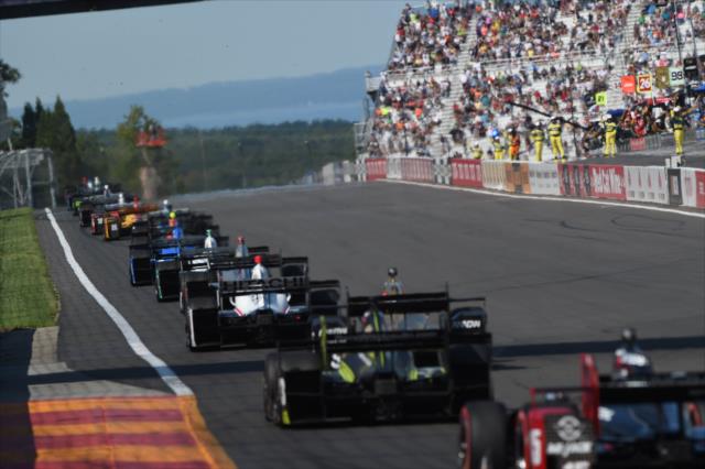 The field streams down the frontstretch during the INDYCAR Grand Prix at The Glen from Watkins Glen International -- Photo by: Chris Owens