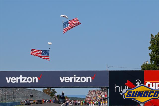 Skydivers bring in the American flag during pre-race festivities for the INDYCAR Grand Prix at The Glen from Watkins Glen International -- Photo by: Mike Harding